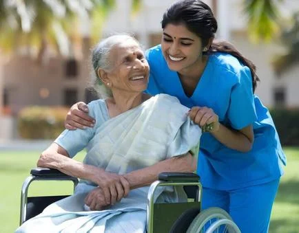 Care attendant holding hands with an elderly grandmother at bedside